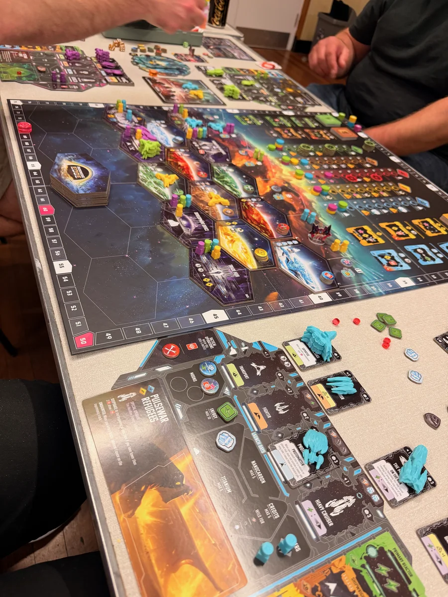 A space board game in progress with pieces and player boards